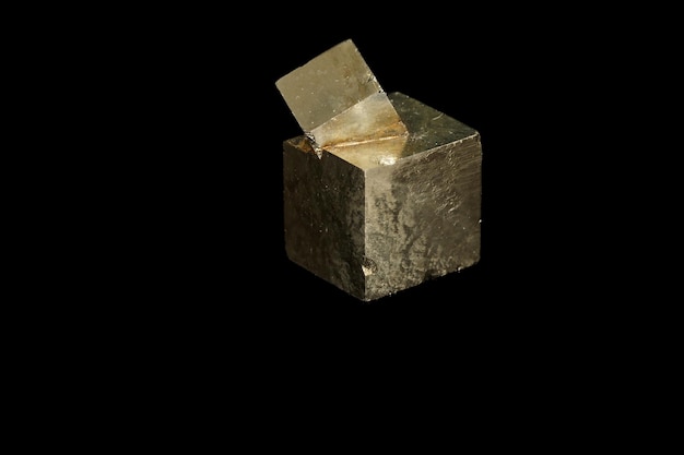 Макроминеральный камень Пирит на черном фоне