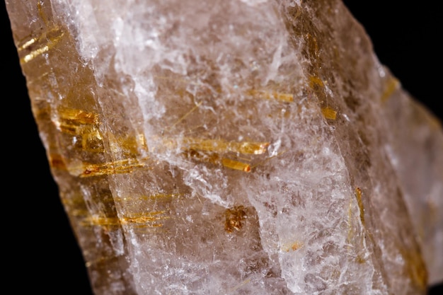 Macro mineral stone Rutile in quartz on black background