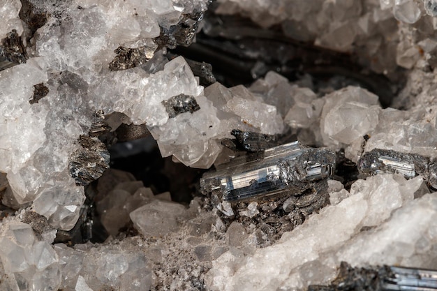 Macro mineral stone Stibnite quartz on a black background