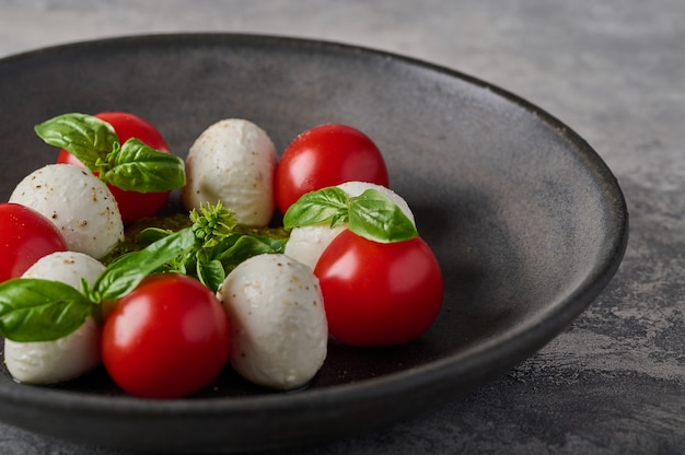 Macro panoramic view italian caprese salad with ripe tomatoes fresh basil and mozzarella cheese in