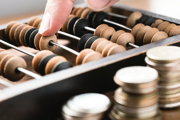 Macro photo of an accountants finger counting money using vintage wooden abacus