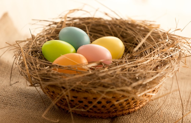 테이블에 둥지에 누워 다채로운 부활절 달걀의 매크로 사진