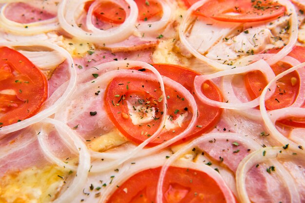 Macro photo of ham with bacon and onion on pizza 