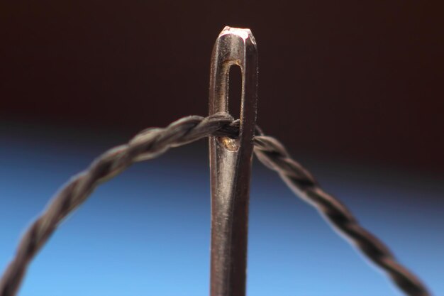 Macro photo of a needle and black thread
