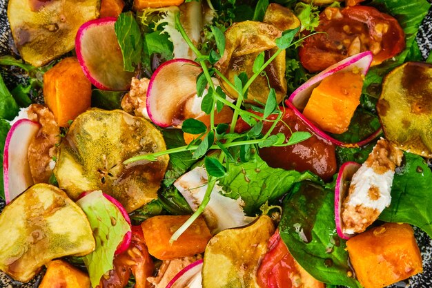 Macro photo of salad with soft cheese, radish, pear, pumpkin and sun dried tomato