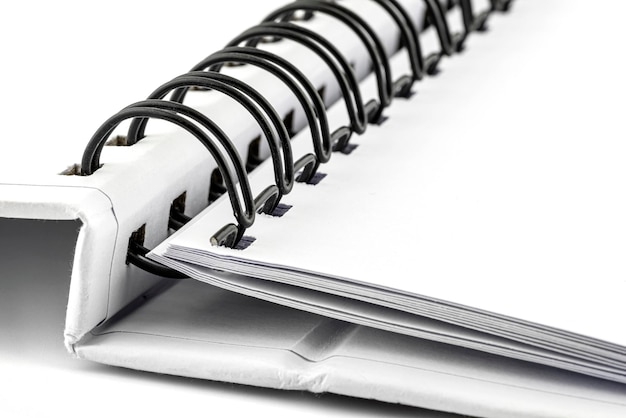 Photo macro photo of a white notebook with a black metal spiral connecting the pages