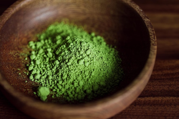 Macro photography of matcha green tea powder in a wooden bowl