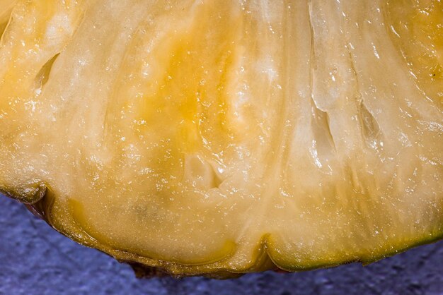 Fotografia macro di una fetta di ananas su uno sfondo scuro dettaglio della polpa e della buccia