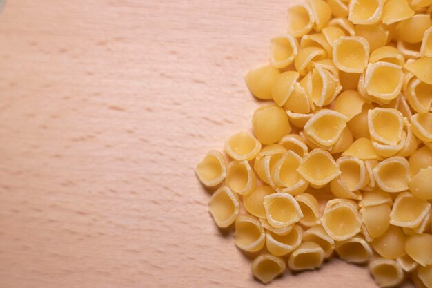 Foto fotografia macro di pasta italiana cruda a forma di guscio per comprendere un concetto