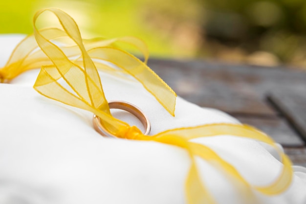 Photo macro photography of wedding rings laid on a yellow ribbon