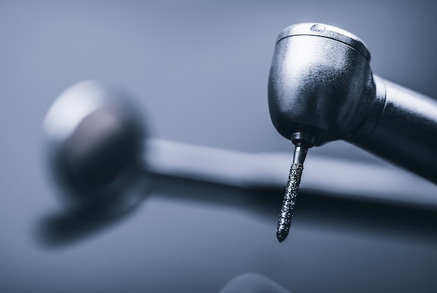 Macro of shiny metal dental drill tool on light gray background