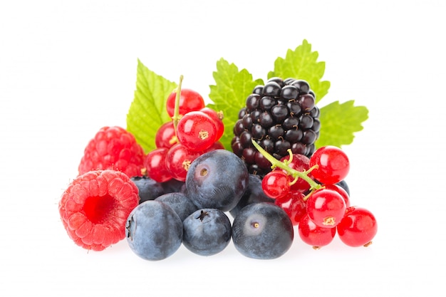 Macro shot of fresh raspberries, blueberries, blackberries, red currant and blackberry with leaves isolated on white background.