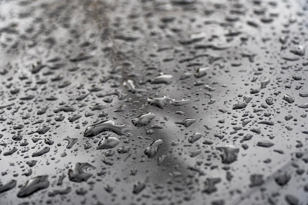Foto scatto macro di gocce di pioggia su una superficie metallica ideale per creare modelli e sfondi unici