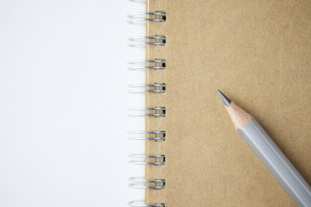 Macro shot of sharpened pencil on brown notebook