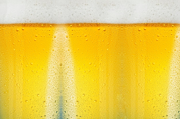 Macro shot of a water drops on the glass filled with beer