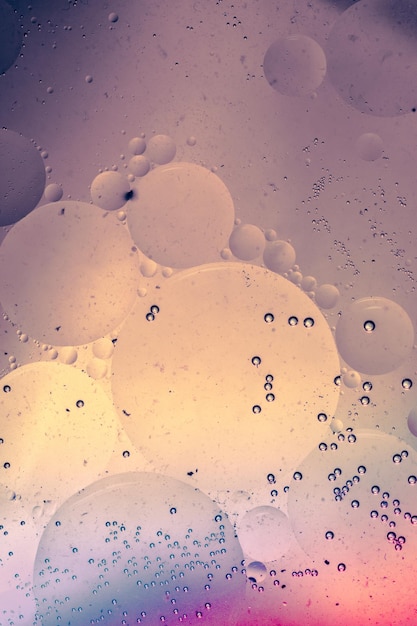 Macro shot of water oil emulsion over colored background