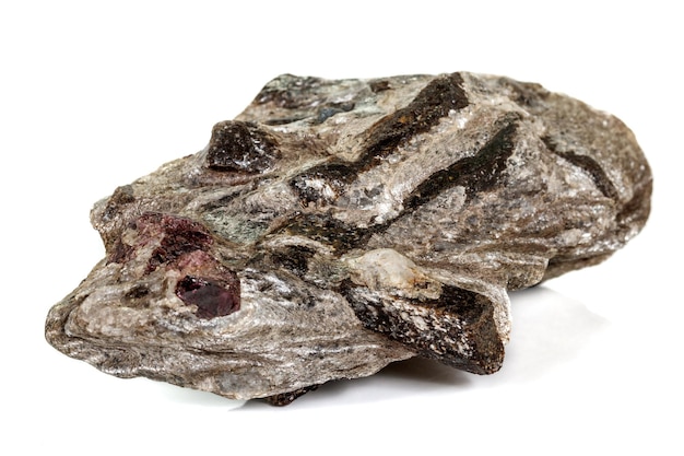 白い背景の上の岩のマクロ石ガーネット鉱物