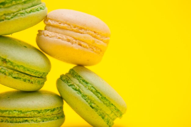 Macro sweet french macaroons over yellow background.Great desset