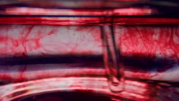 Макро пробирки с кровью Перемешивание красной жидкости в стеклянной посуде пипеткой