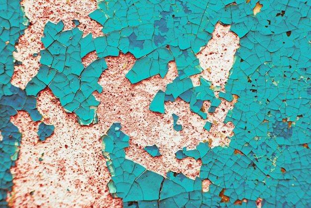 Foto macro textuur van gebarsten verf op het oppervlak vintage achtergrond in trendy rode en turquoise kleuren gedetailleerde textuur