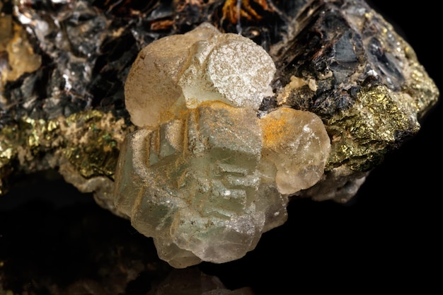 Foto macro van een minerale steen sfaleriet met fluoriet en pyriet op een zwarte achtergrond close-up