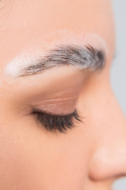 Macro van wenkbrauwen die correctie ondergaan en langdurige styling die de wenkbrauwen van de wenkbrauwen vormgeeft in schuim Selectieve focus close-up