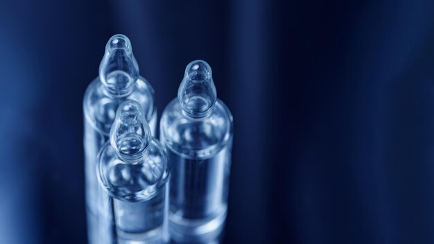 Macro view of Glass ampoules with medicine on dark blue background