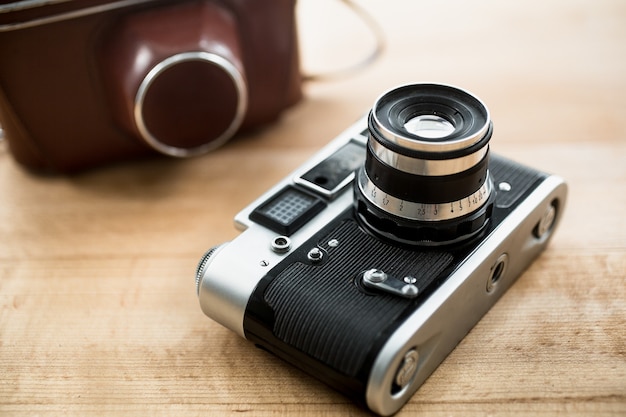 Macro view of retro manual camera and leather case lying on table