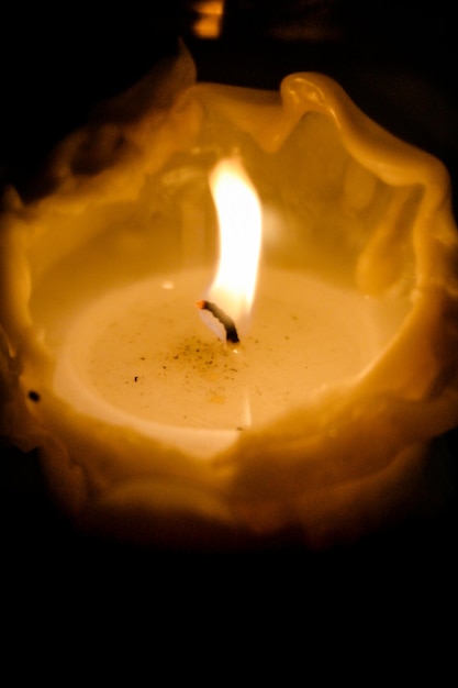 Macro view of a wax candle lit on black background