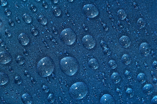 Macro of water drops on the blue surface