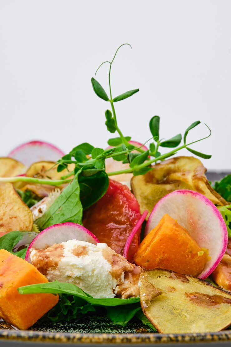 Foto macrofoto van salade met zachte kaas, radijs, peer, pompoen en zongedroogde tomaat
