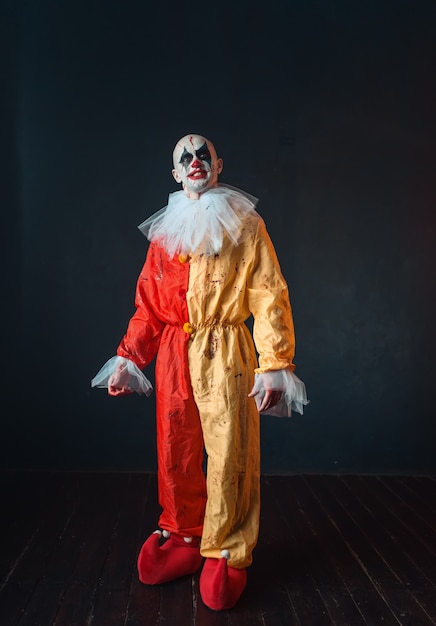 Mad bloody clown with makeup in carnival costume, crazy maniac, scary monster