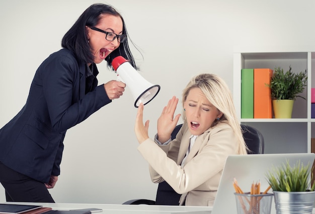 Mad boss shouting at employee on megaphone