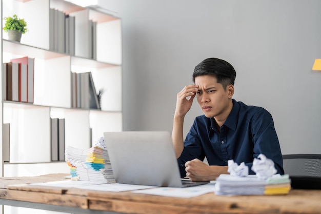 Mad crazy man employee sitting in office workplace with sticky notes all around shouting furious angry pissed off deadline and stressful job at office