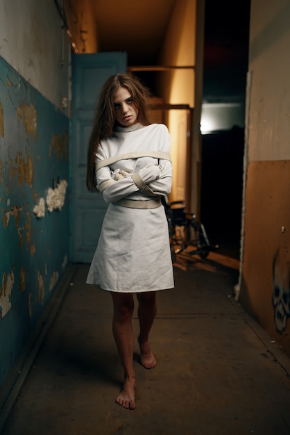 Photo mad female patient in straitjacket, mental hospital. woman in strait jacket undergoing treatment in clinic for the mentally ill