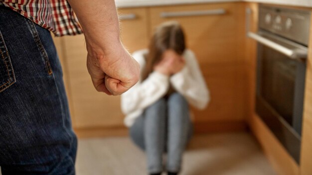 Photo mad man beating and threating young woman crying on floor concept of domestic violence parent