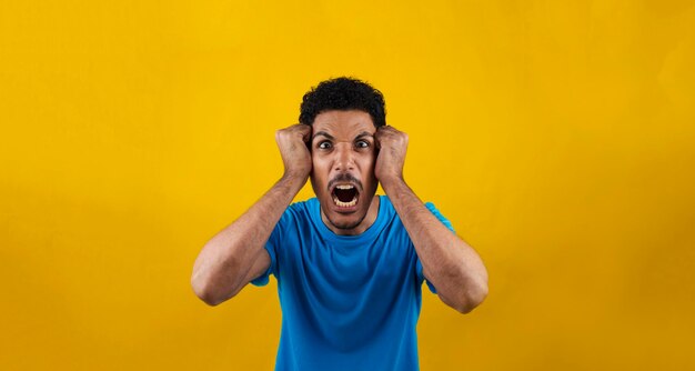 Mad man isolated on yellow background. handsome black man with blue shirt on yellow.