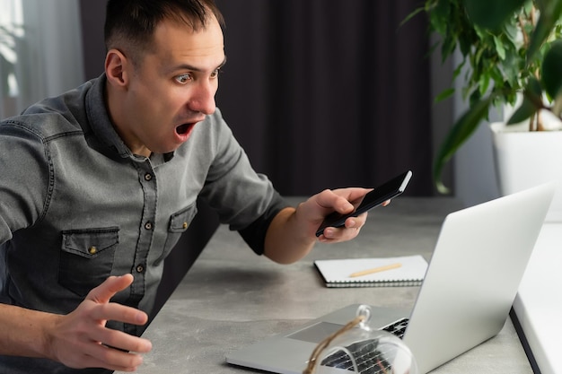 Mad stressed young man angry about stuck laptop or pc failure, furious guy annoyed with computer problem virus, user confused by fake bad online news, frustrated with notebook breakdown or data loss.