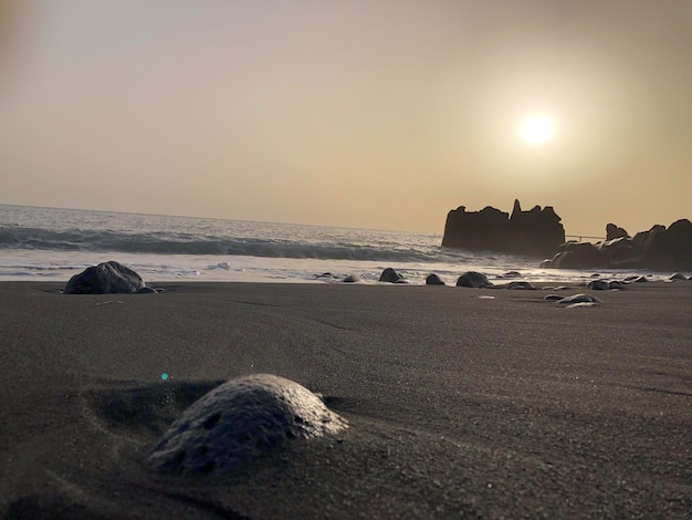 Madeira eiland zwart zand strand zonsondergang oranje zon rots