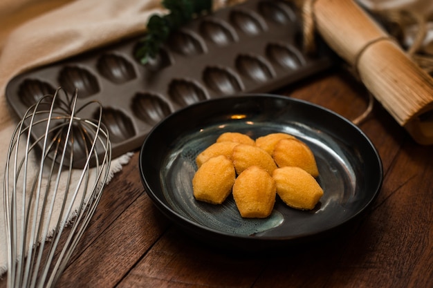 Madeleine with ceramic plate on a wooden table