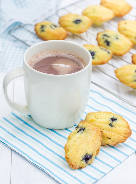 Madeleines met bosbessen en een kop warme chocolademelk