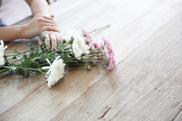 Madeliefjesbloemen op hout met meisjeshand