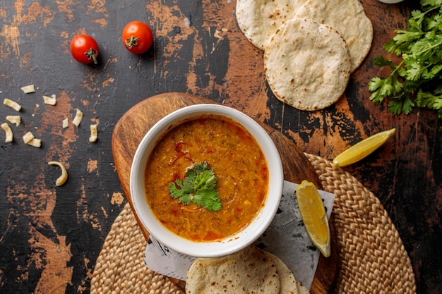 Madrooba or Madrouba soup with bread lime and tomato cherry served in dish isolated on table top view of arabic breakfast