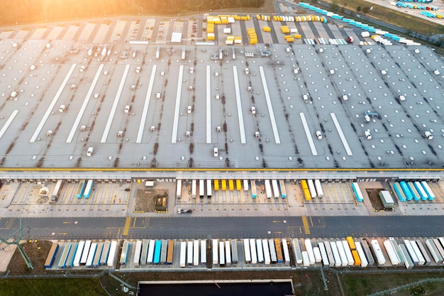 Magazijn en goederen bovenaanzicht van vrachtwagens die wachten op laden in de buurt van magazijn met goederen uit online winkel logistiek magazijn