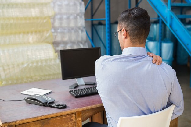 Magazijnmanager die op computer werkt