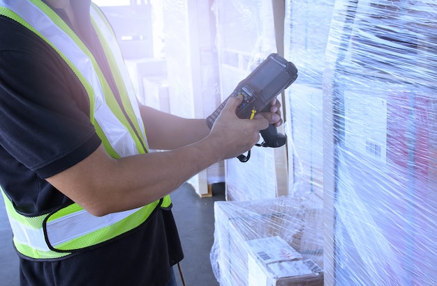Foto magazijnmedewerker houdt barcodescanner bij met inventaris en controleert de producten