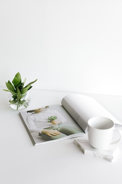 A magazine on a table with a white napkin and a cup of coffee.