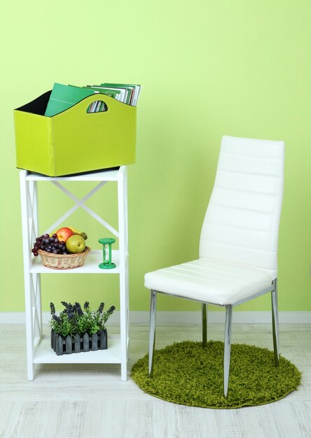선반의 녹색 상자와 방의 의자에 잡지 및 폴더