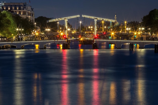 Magere brug magere brug met nachtverlichting over de rivier de amstel in het centrum van amsterdam