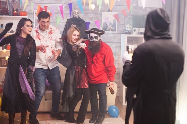 Magere hein die foto's maakt van piraat en zijn vrienden op halloween-feest.